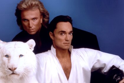 Siegfried Fischbacher and Roy Horn posing with a white tiger