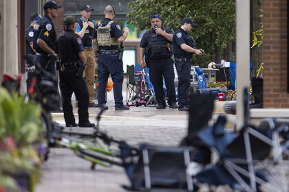 Law enforcement officers respond to the scene of a mass shooting along the Fourth of July parade