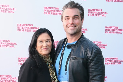 Barbara Kopple and Collier Landry pose together in front of a step and repeat