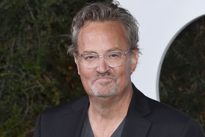 Matthew Perry in front of a step and repeat at an event.