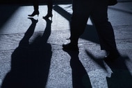 A shadow of legs of a man and woman being stalked at night