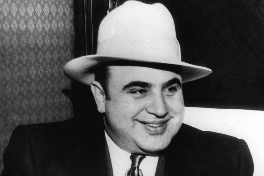 Al Capone wears a hat and smiles in 1930