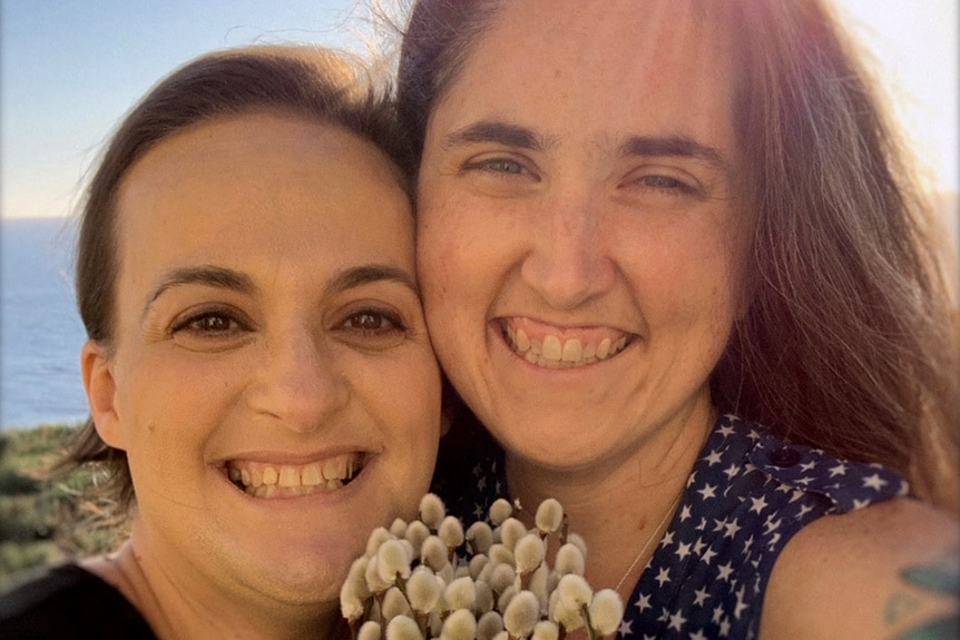 Elisabeth Finch and Jenn Beyer pose together with flowers on Anatomy of Lies Season 1 Episode 2