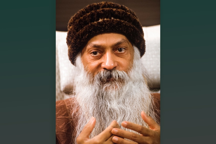 Bhagwan Shree Rajneesh wears a hat and has a long white beard