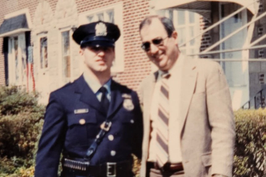 Chris McMullin stands with his father Paul McMullin in his police uniform