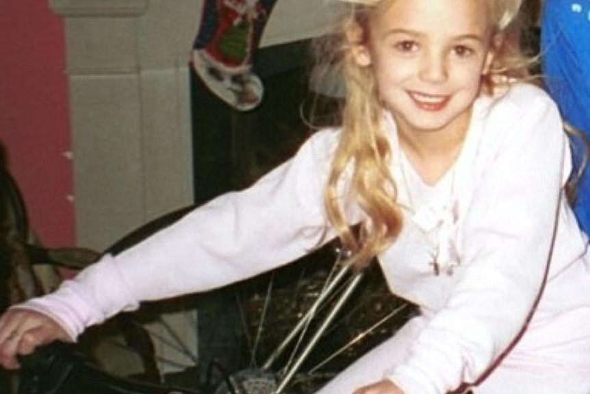 JonBenét Ramsey smiles on a bike