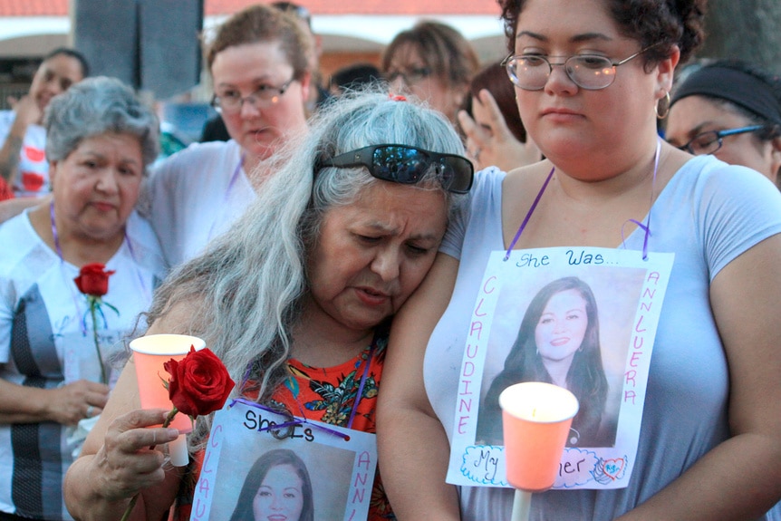 Family members hold candles during a vigil of victims of Juan David Ortiz