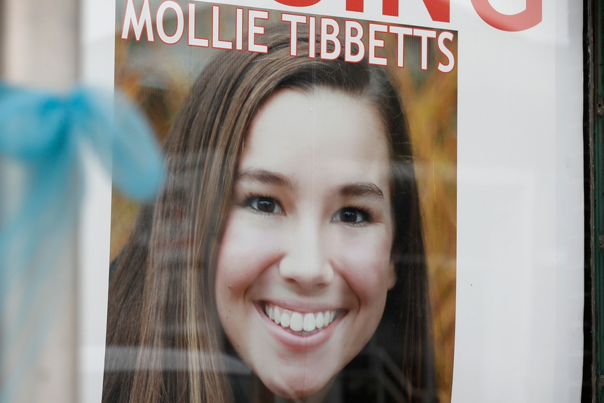 A missing persons poster of Mollie Tibbetts is posted on a window